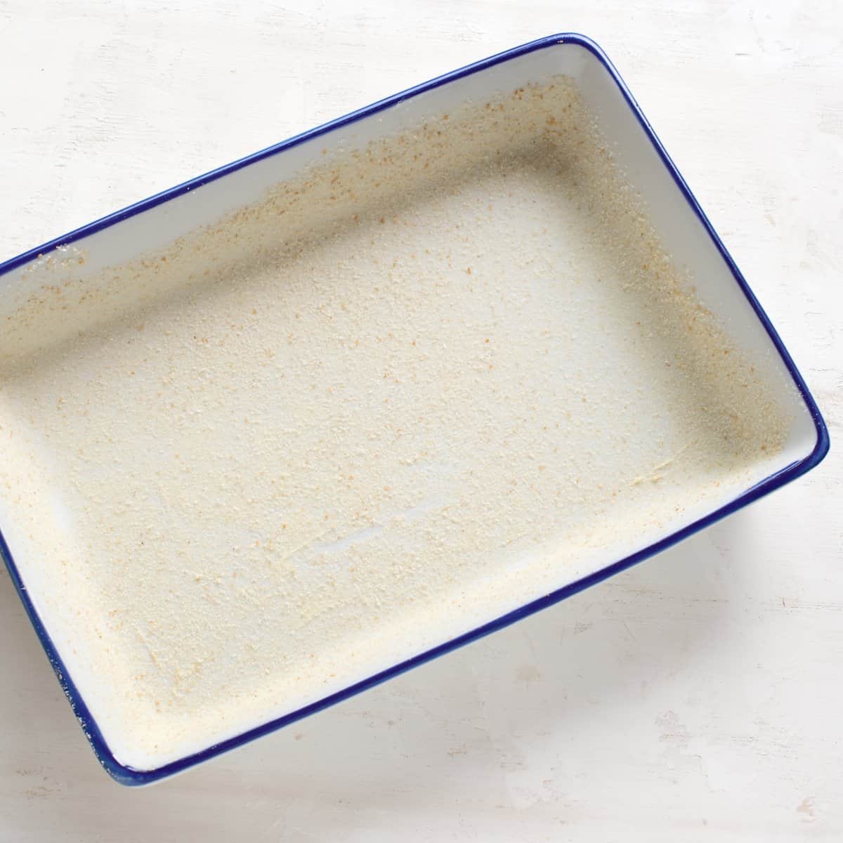A baking dish dusted with breadcrumbs.