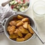 Roasted breadcrumb potatoes served with a glass of milk and veg salad.