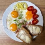 Czech Hemenex - ham and eggs served on a plate with veggies and two slices of bread.