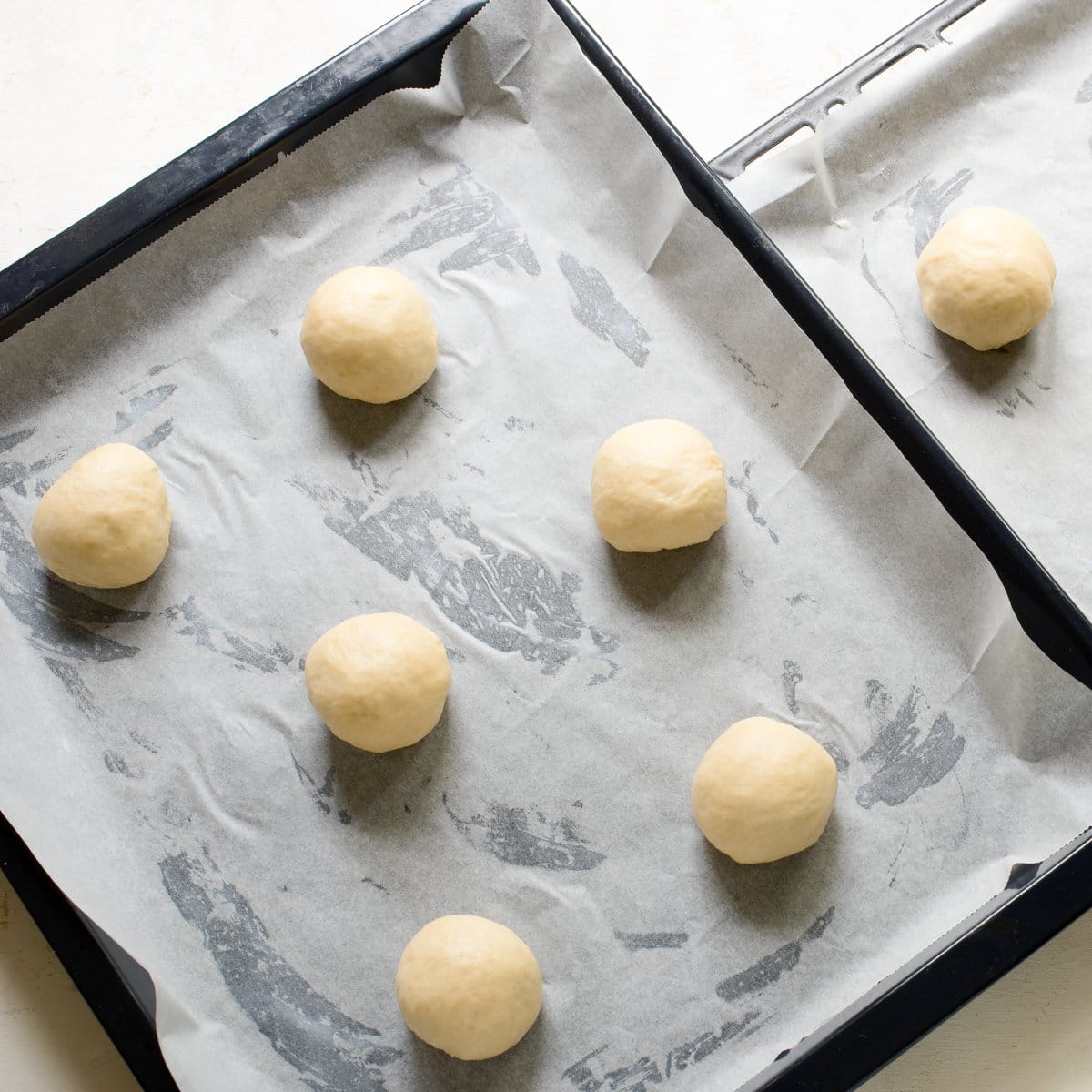 Small ball of dough for Kolache on a baking sheet.