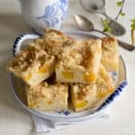 Czech buchta with canned peaches, sliced, served on a dessert plate.