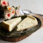 Two pieces of Czech Tvarožník cake served on a green plate.