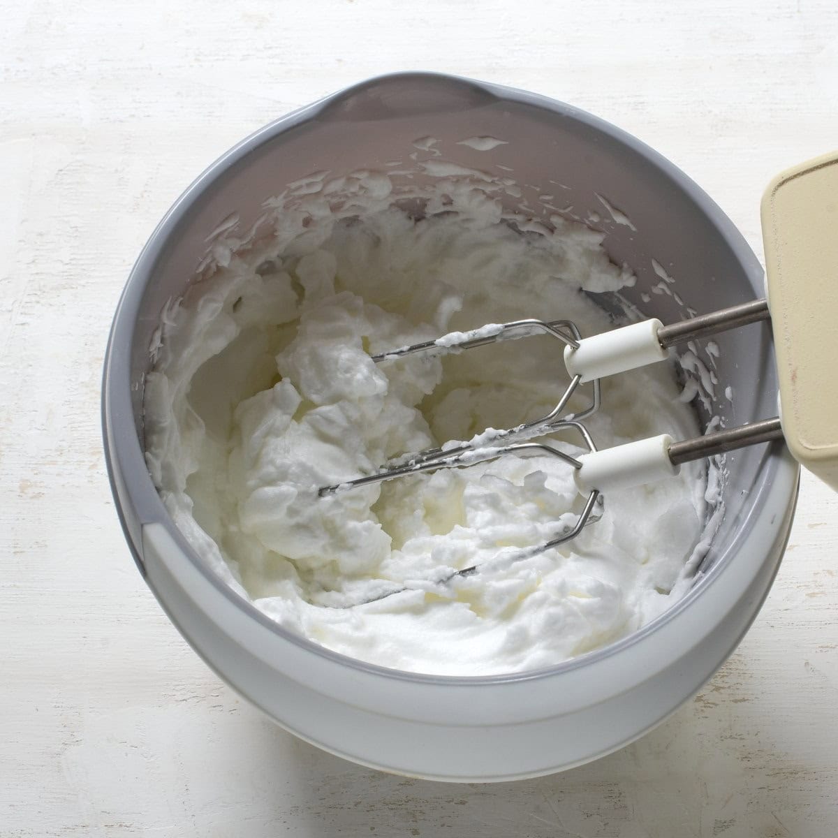 Stiff-beaten egg whites in a gray bowl.