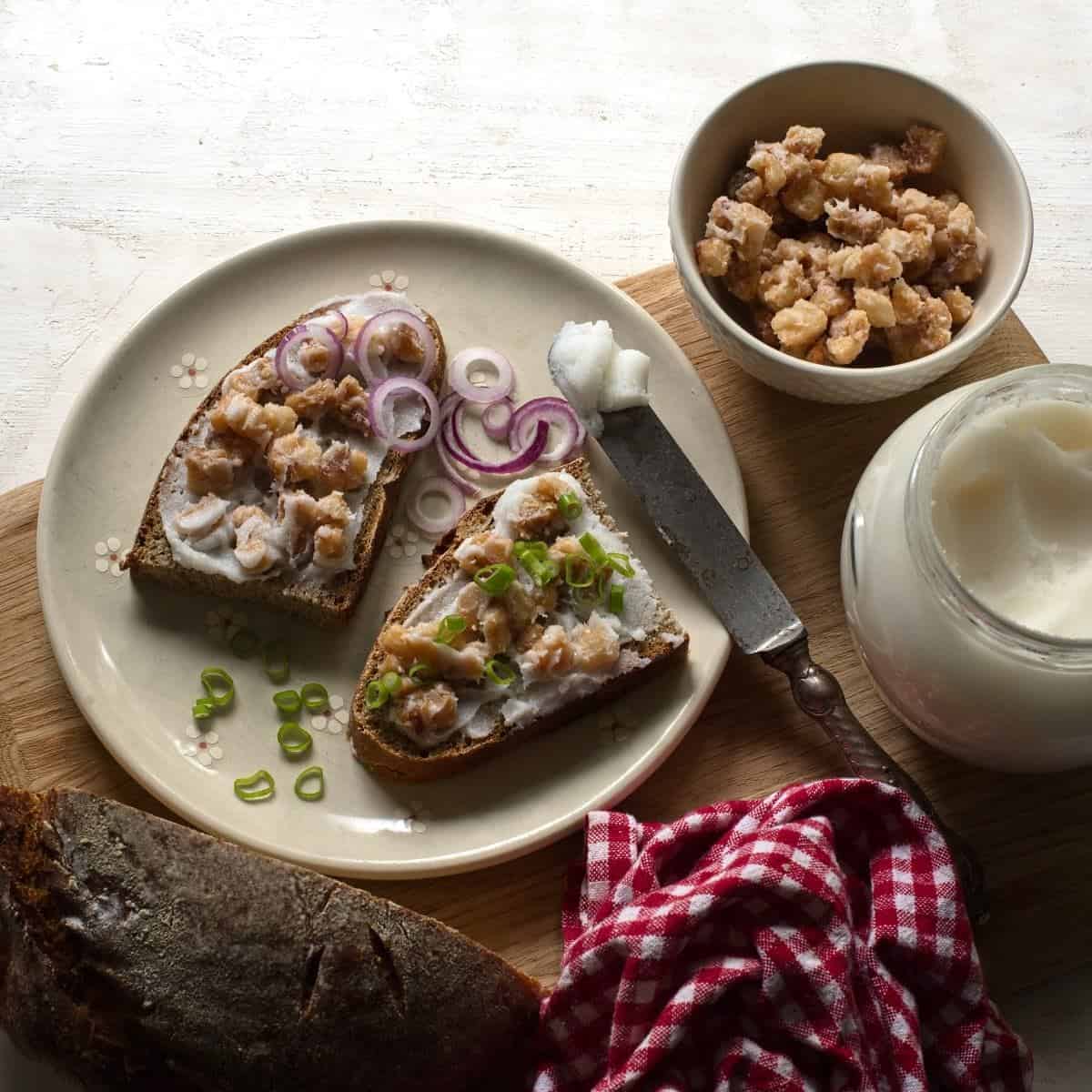 Two slices of bread smeared with lard, with a sprinkle of cracklings.