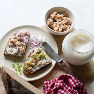 Two slices of bread spread with lard, with a sprinkle of cracklings.