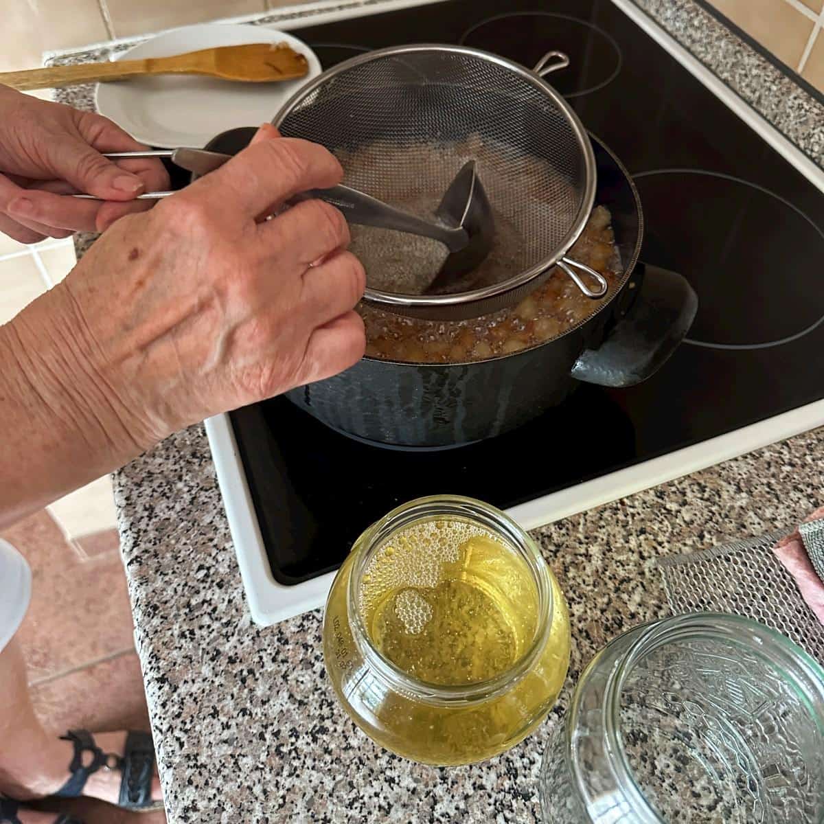 Removing rendered lard and ladling into jars.