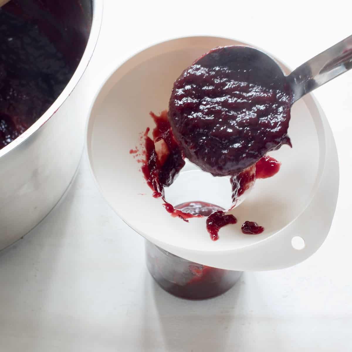 Filling plum butter into jars.