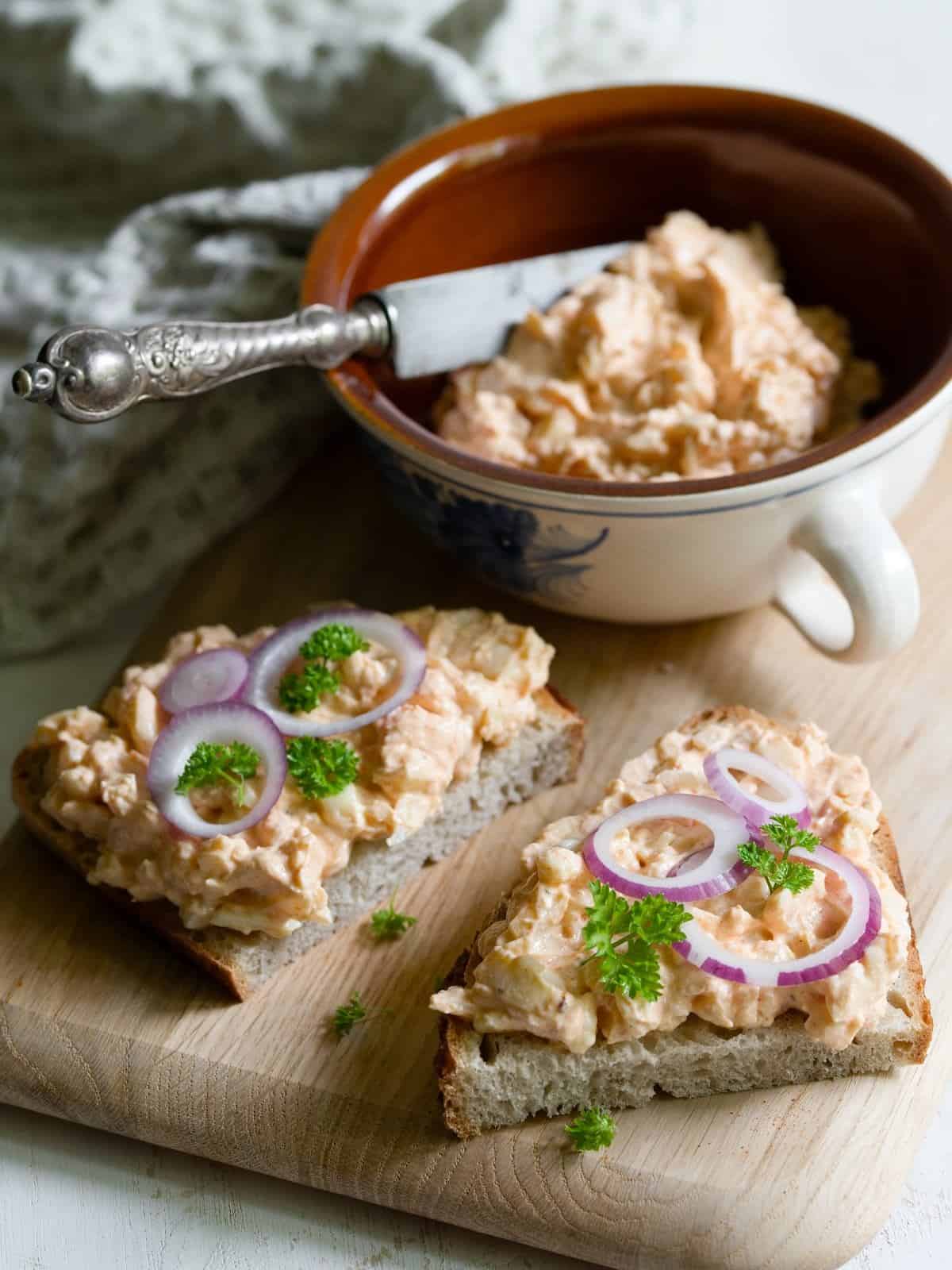 Czech Romadur cheese bread spread on two slices of bread, served on a wooden board.