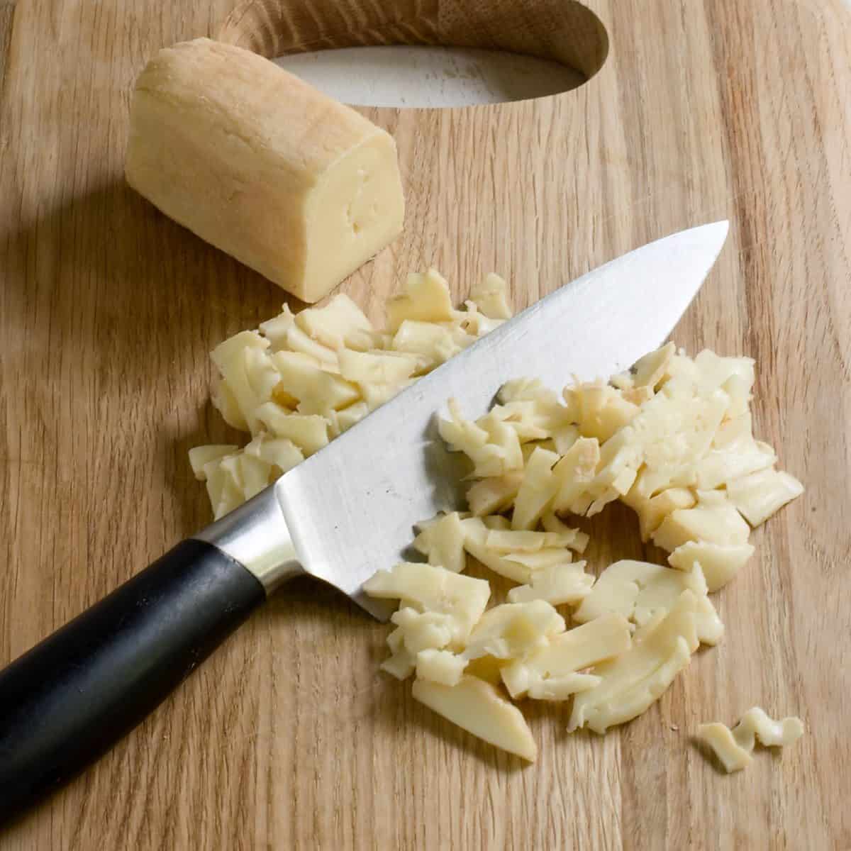 Cutting Czech Romadur cheese into smaller pieces, using a kitchen knife.