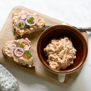 Czech Romadur cheese bread spread on two slices of bread, served on a wooden board.