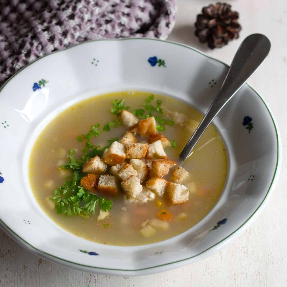Czech rybí polévka (fish soup) served with bread croutons in a plate.