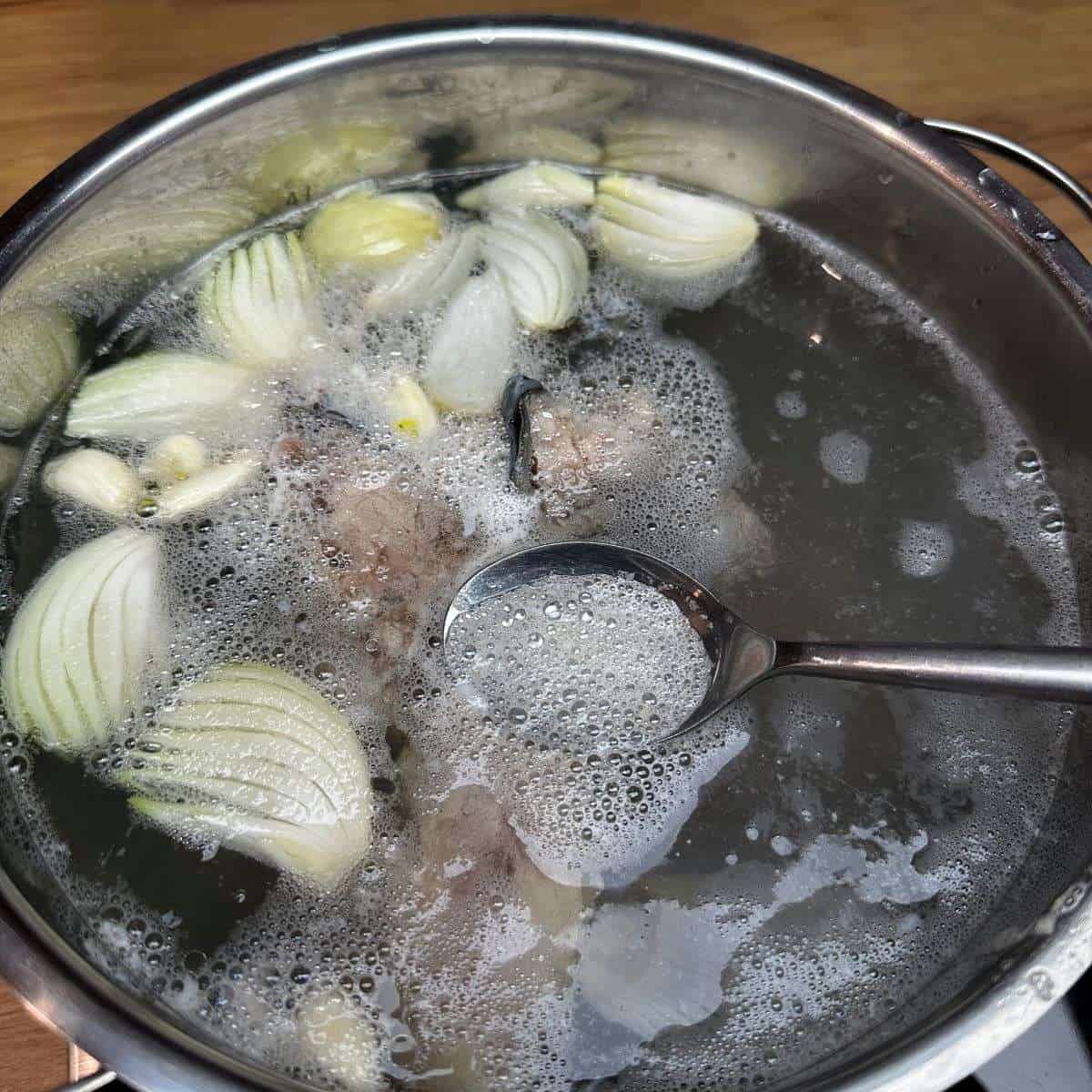 Skimming of foam on a soup surface.