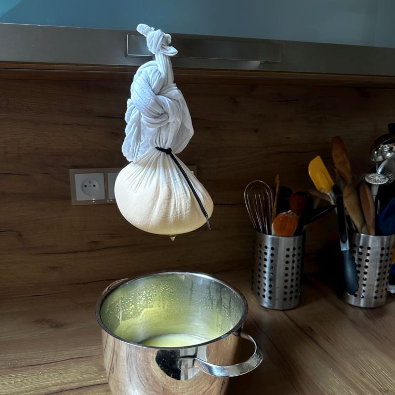 Slovak egg cheese in a cloth hanging over a pot of wheat, dripping.