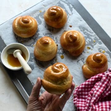 Baked Jidáše, Czech Easter pastry, honey-glazed, still on a baking sheed lined with baking paper.