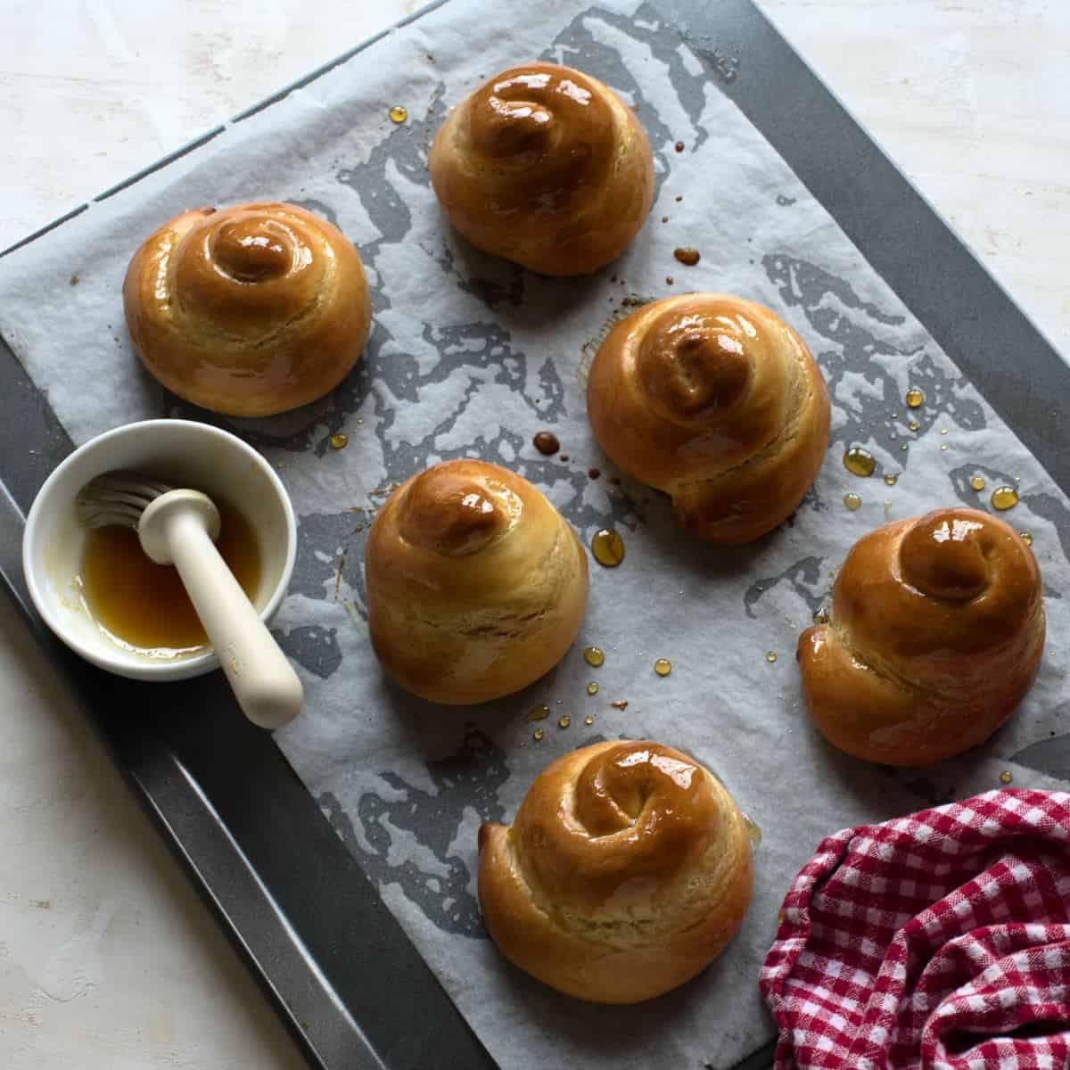 Baked Jidáše, Czech Easter pastry, honey-glazed, still on a baking sheed lined with baking paper.