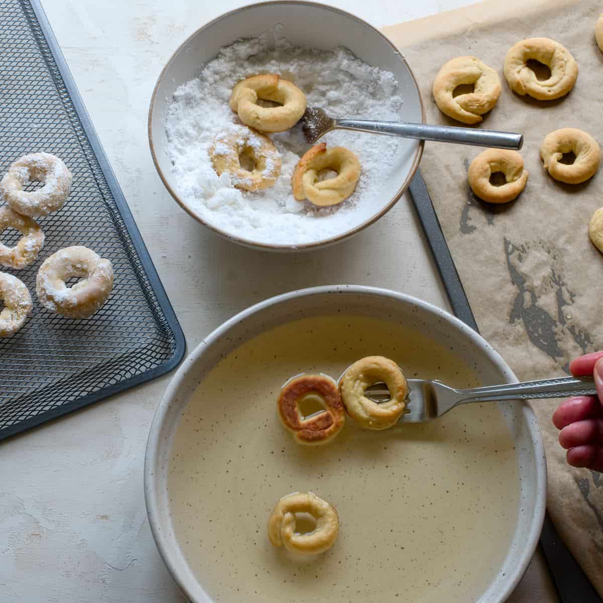 Dipping baked Lomnice kroužky in syrup and coating them in sugar.