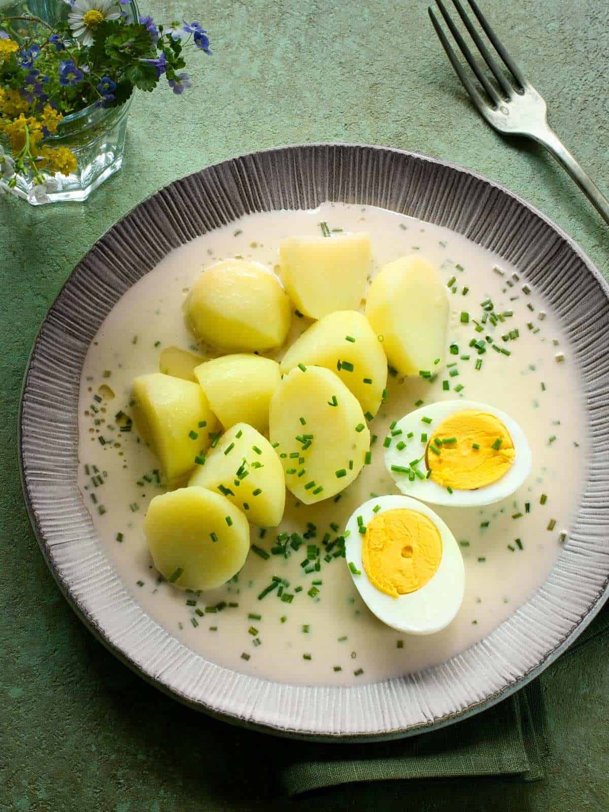 Czech pažitková omáčka - chive sauce - served with a halved hard-boiled egg and potatoes.