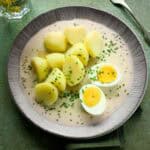 Czech pažitková omáčka - chive sauce - served with a halved hard-boiled egg and potatoes.