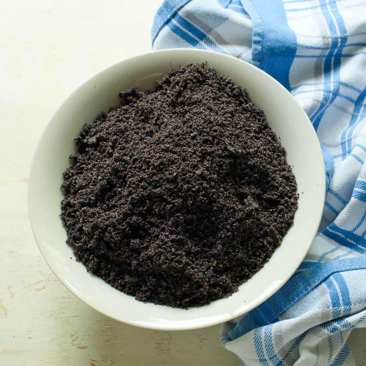 Ground poppy seeds in a white bowl.