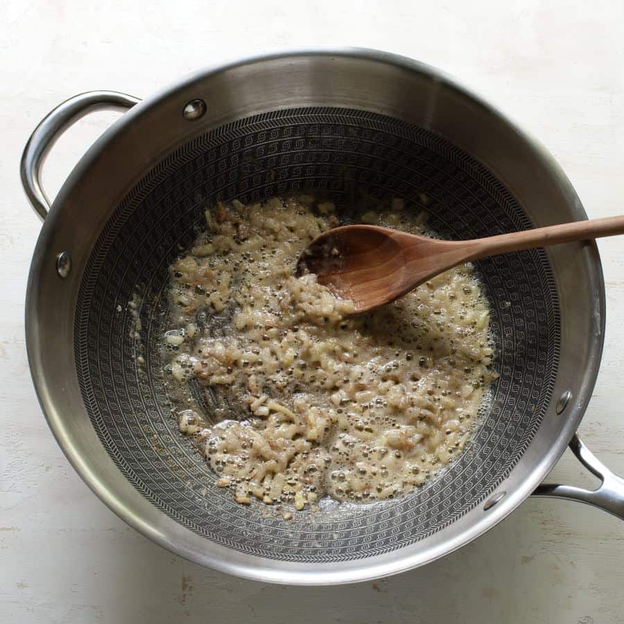 Making onion roux in a saucepan.
