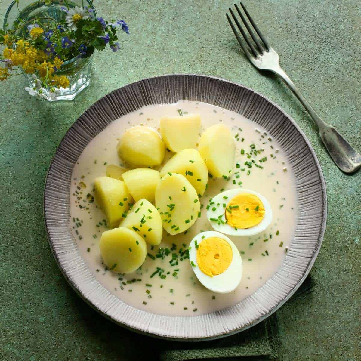 Czech pažitková omáčka - chive sauce - served with a halved hard-boiled egg and potatoes.
