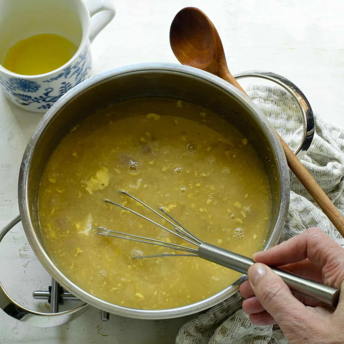 Whisking bread soup after adding eggs to thicken.
