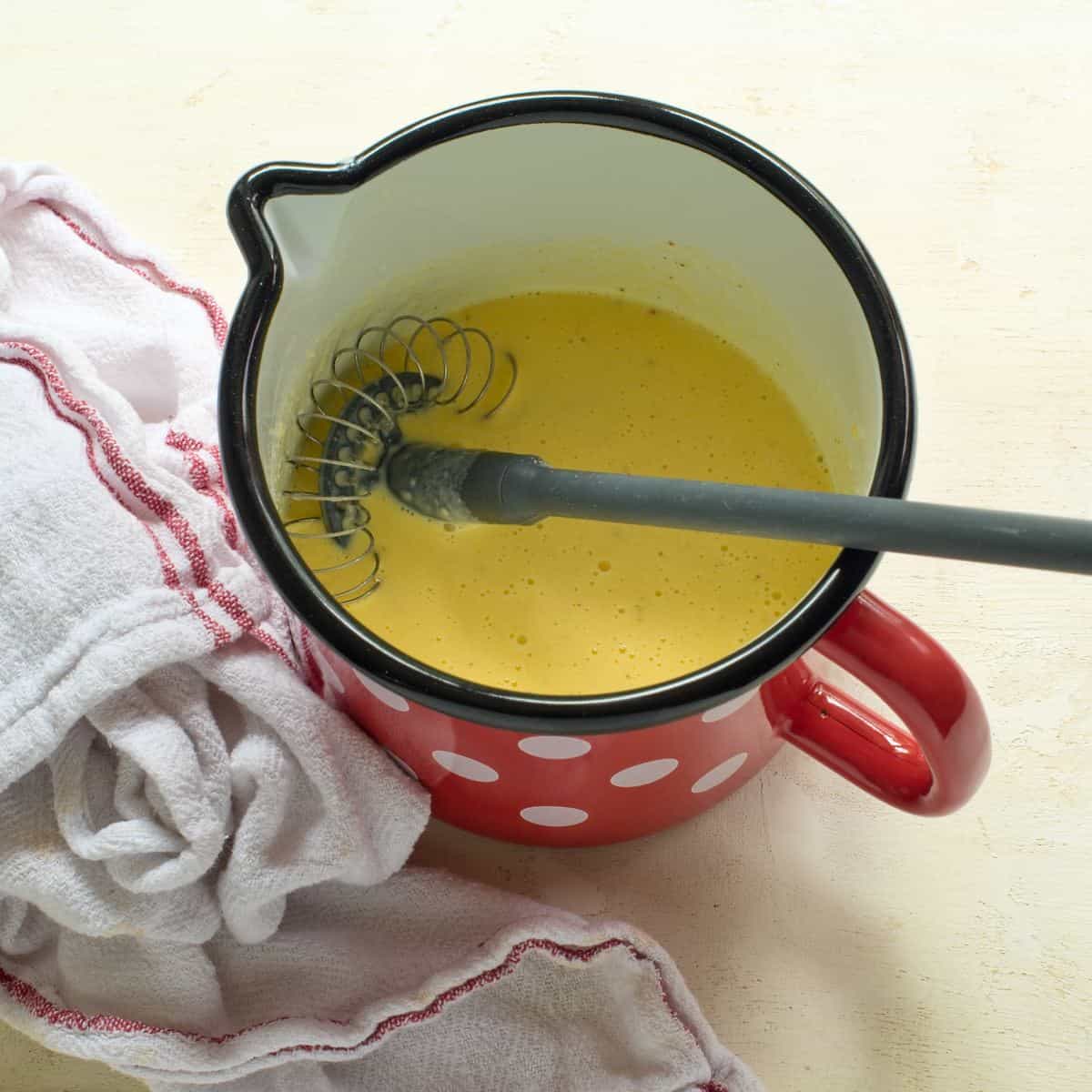 Mixture of egg yolks and cream in a small saucepan.