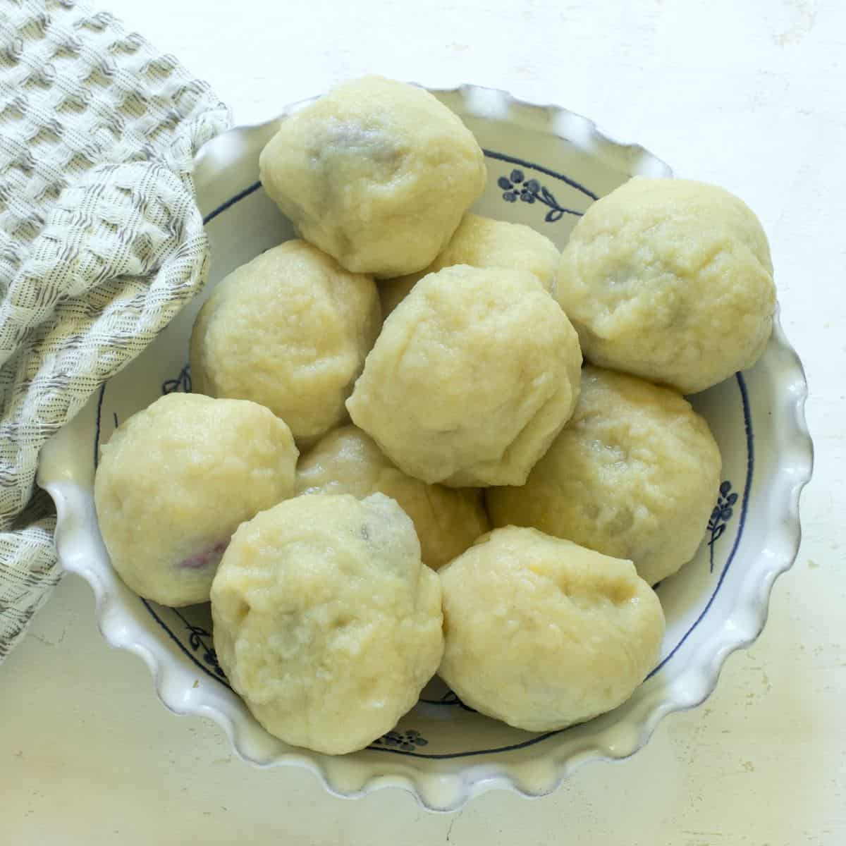 Cooked plum dumplings in a bowl.