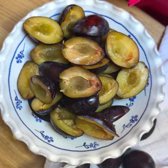 Haved plums in a bowl.