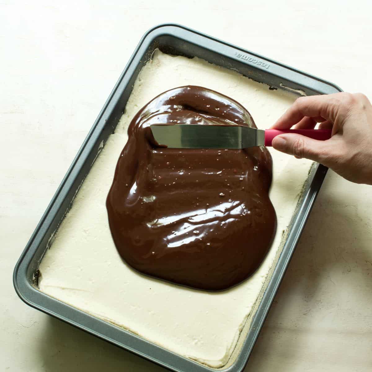Spreading chocolate ganache over white tvaroh cream. Making Czech Míša řezy.